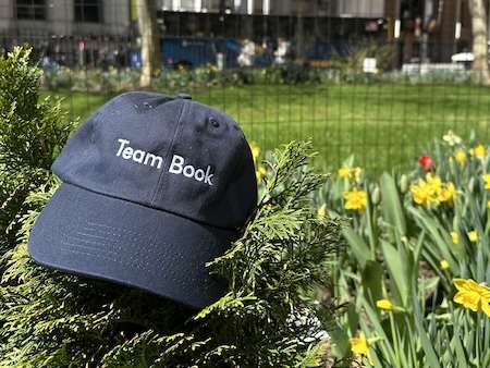 team book hat in the park with flowers
