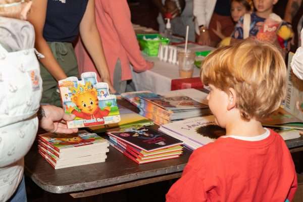 child in front of table of books